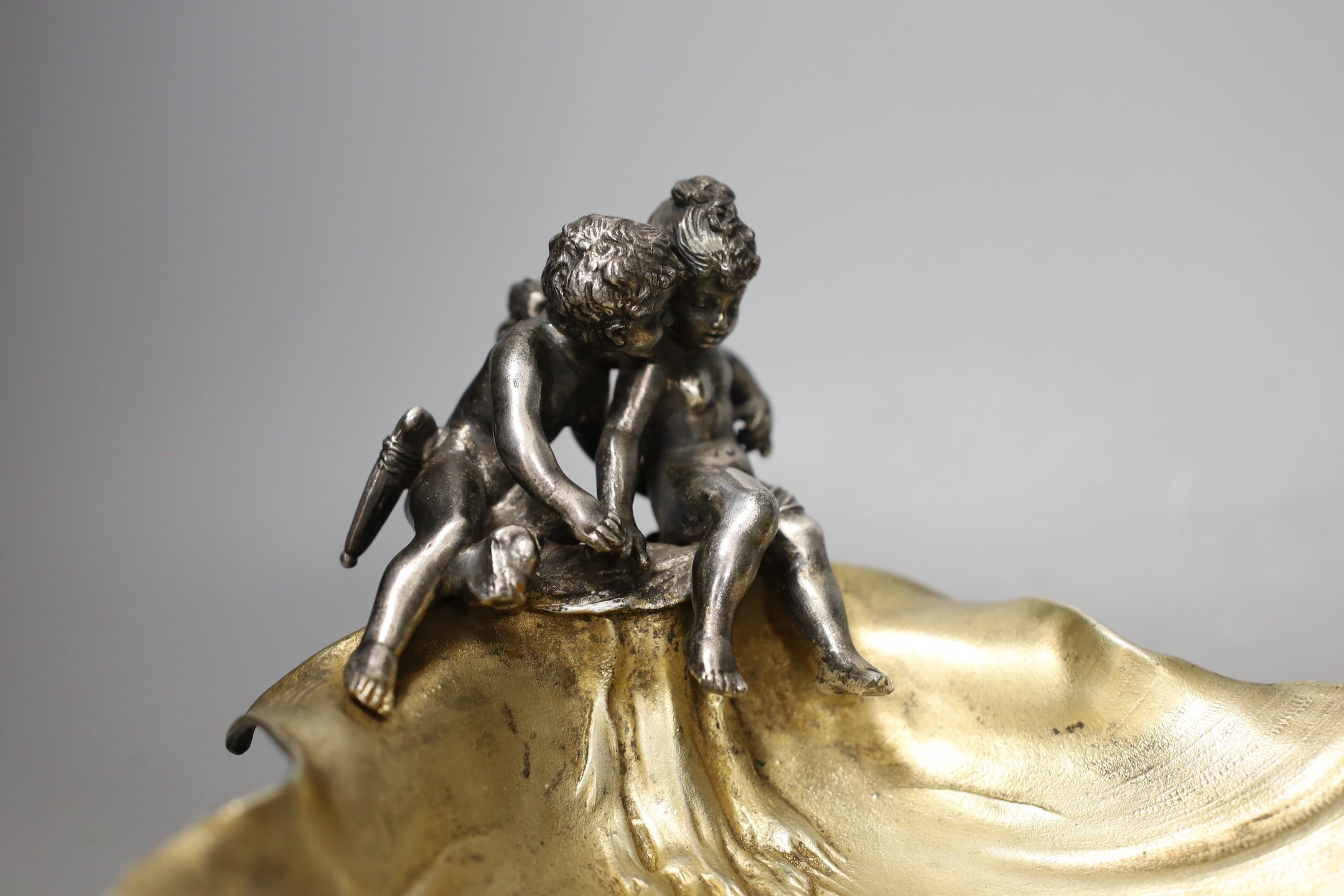 A WMF style plated ‘cherub’ shell dish, and a spelter figure of a seated male reading